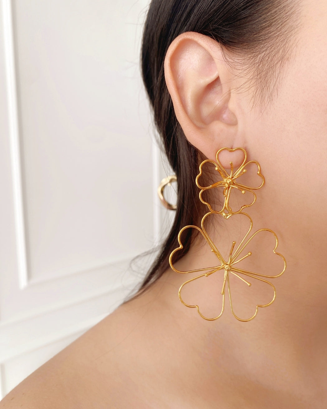Aretes doble flor dorados, diseño elegante con forma de pétalos grandes y ligeros.