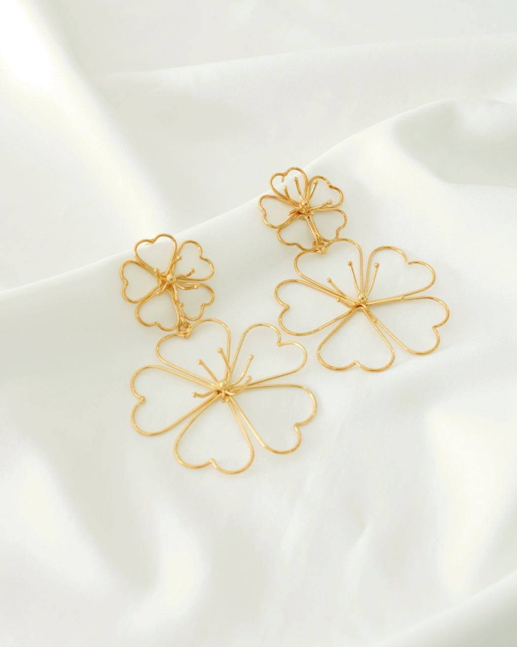 Aretes doble flor dorados, bisutería femenina con diseño floral moderno y llamativo.