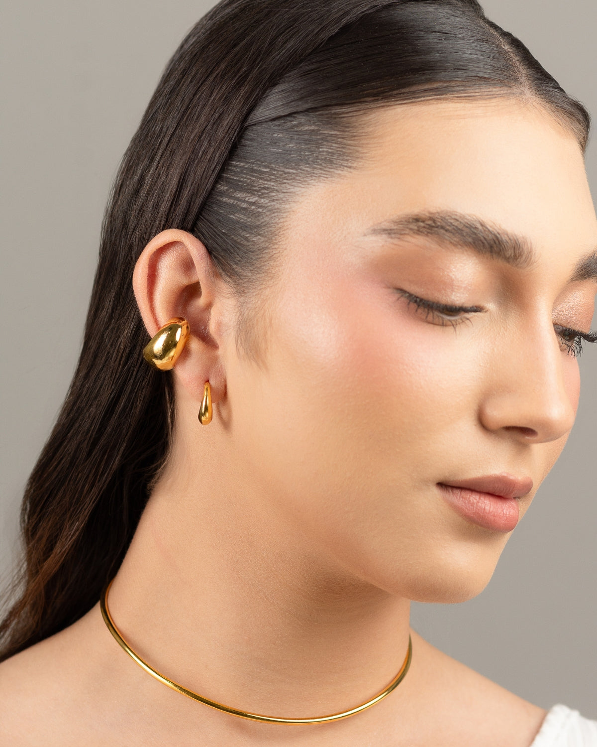 Modelo luciendo el Earcuff Chunky, un elegante accesorio de bronce bañado en oro 24K.