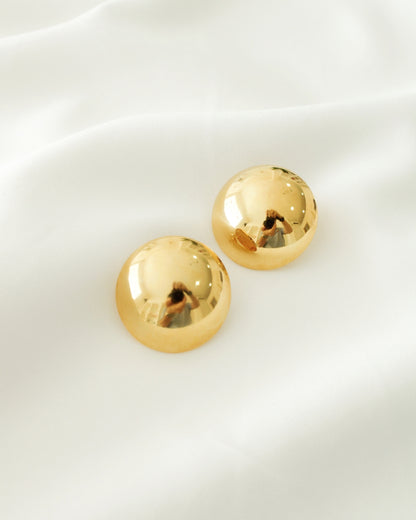 Topos de circulos sencillos dorados presentados en empaque delicado, ideal para regalo o presentación premium.