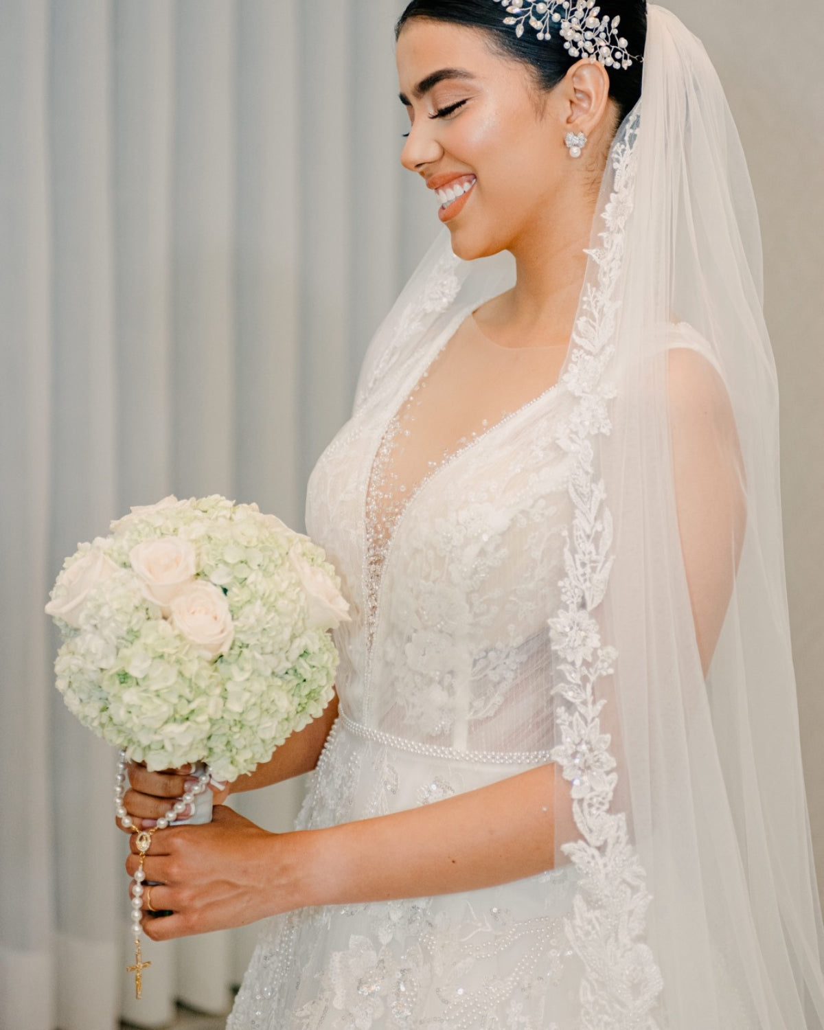 Detalle de camandula de novia dorada con perlas y cruz, un accesorio perfecto para ceremonias religiosas.